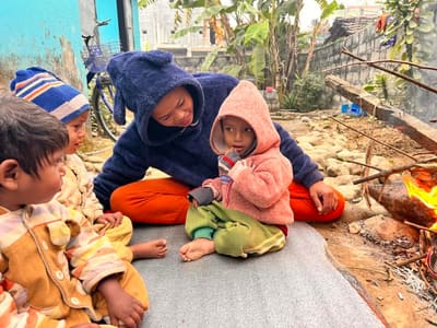 Children keeping warm by the fireside