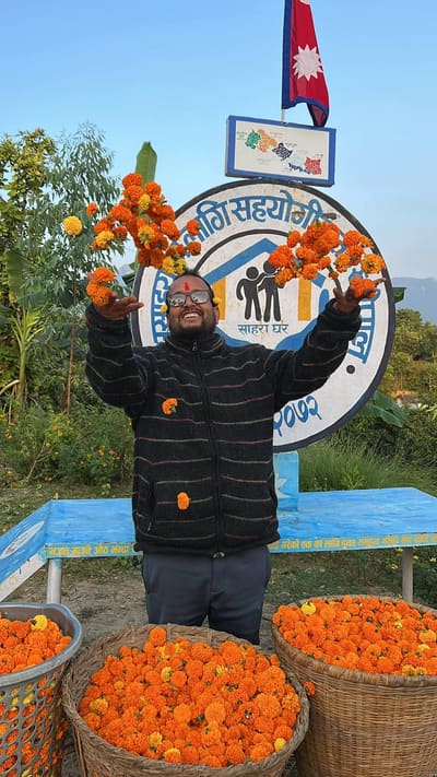 Bal Bahadur Bista celebrating with marigolds at Sahara Ghar